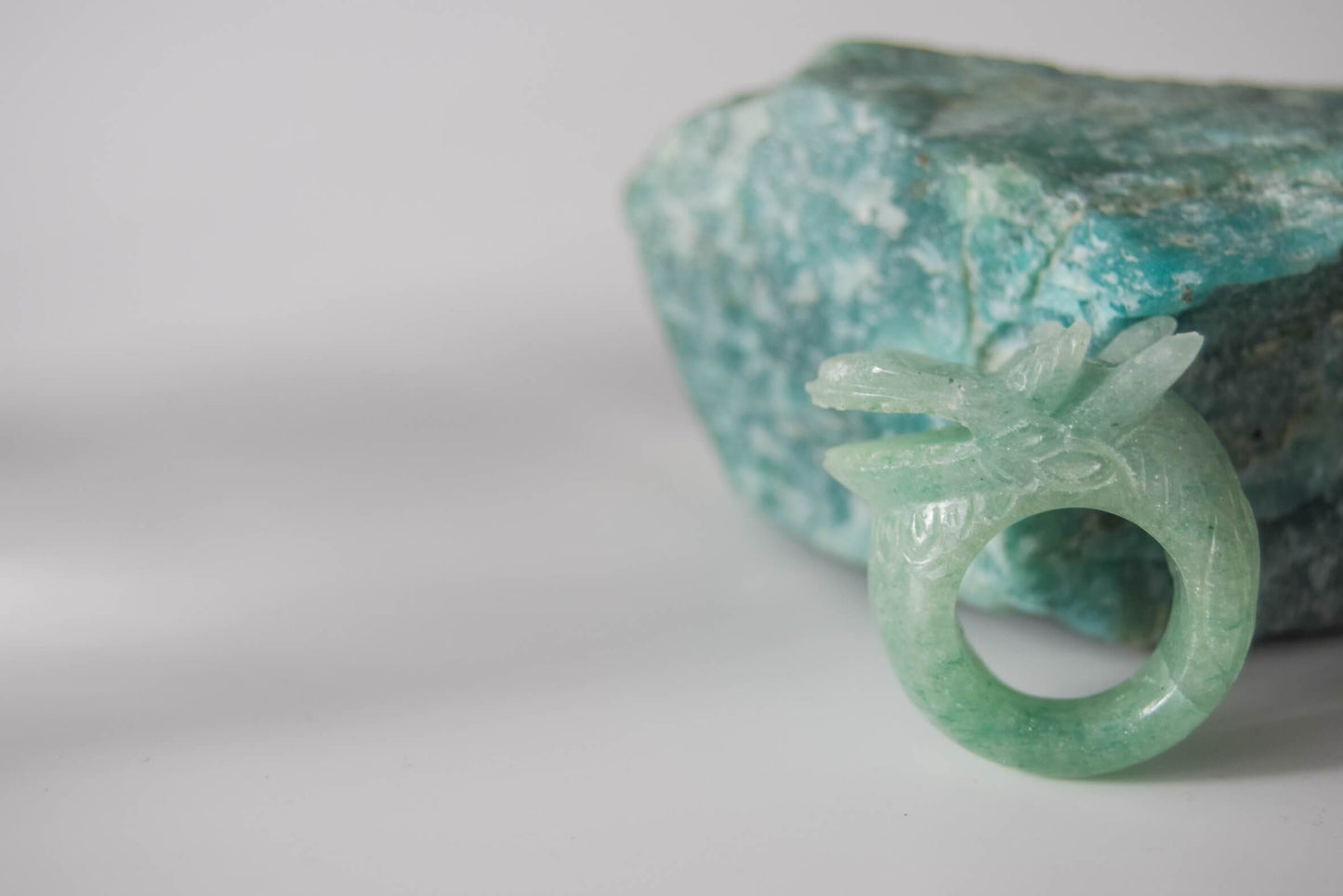 Aventurine stone ring with carved and engraved dragon on a green stone background