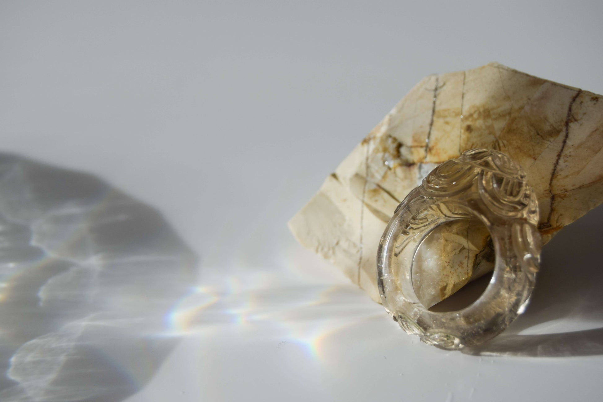 Clear Quartz stone ring with carved and engraved flower on a natural stone background