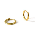 Two gold hoop earrings on a white background