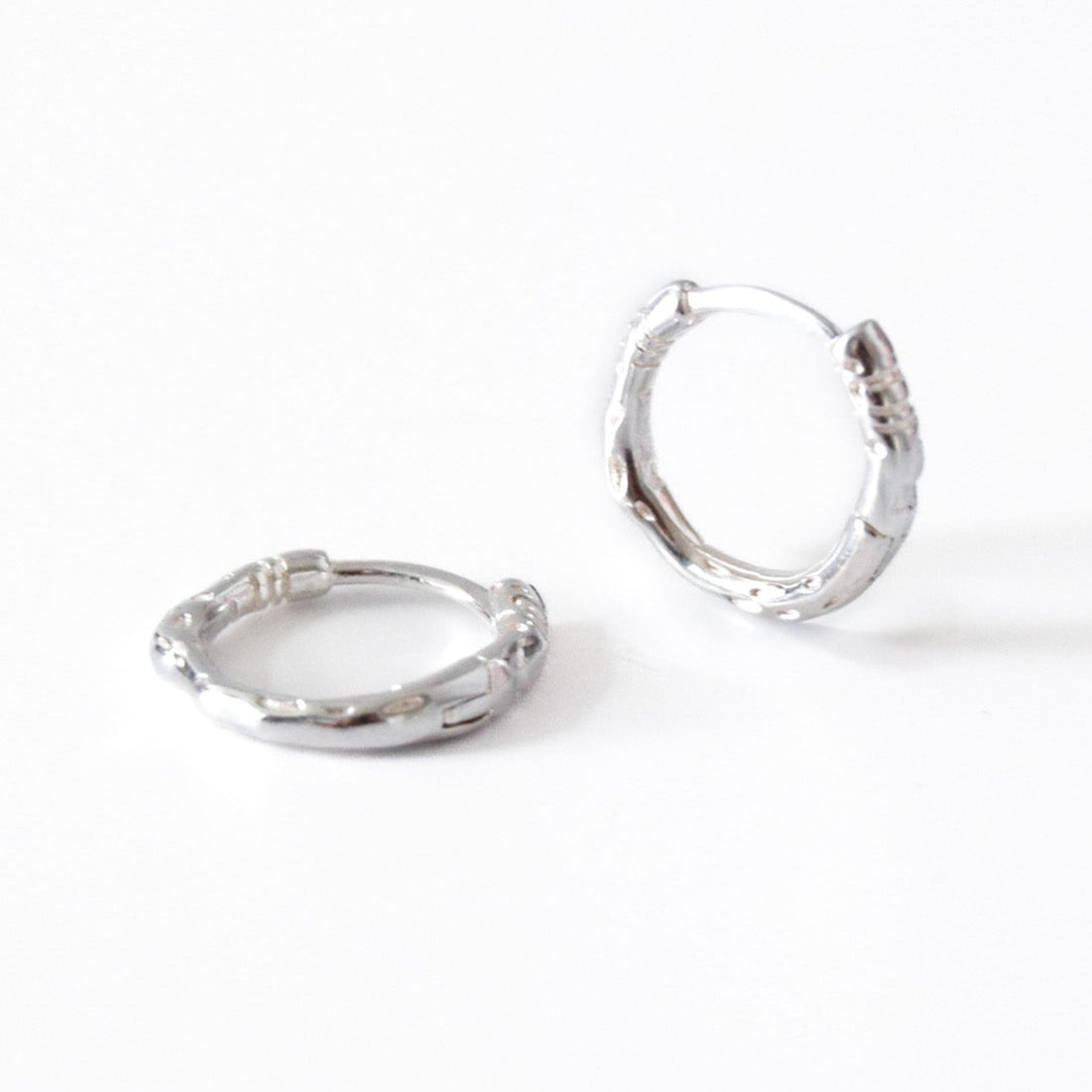 Pair of silver hoop earrings on a white background