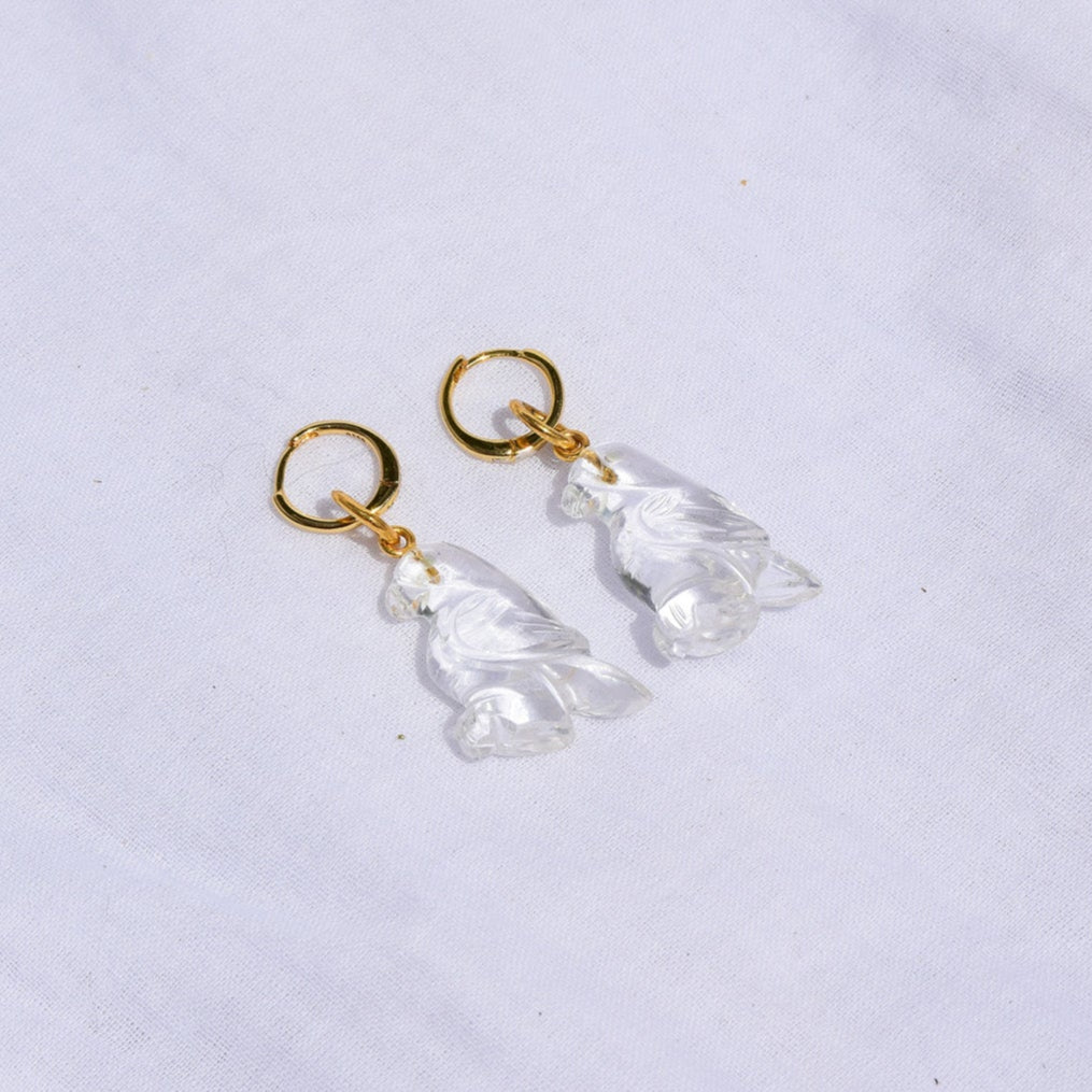 Pair of earrings with gold hooks and clear Bird shaped stones on a white background