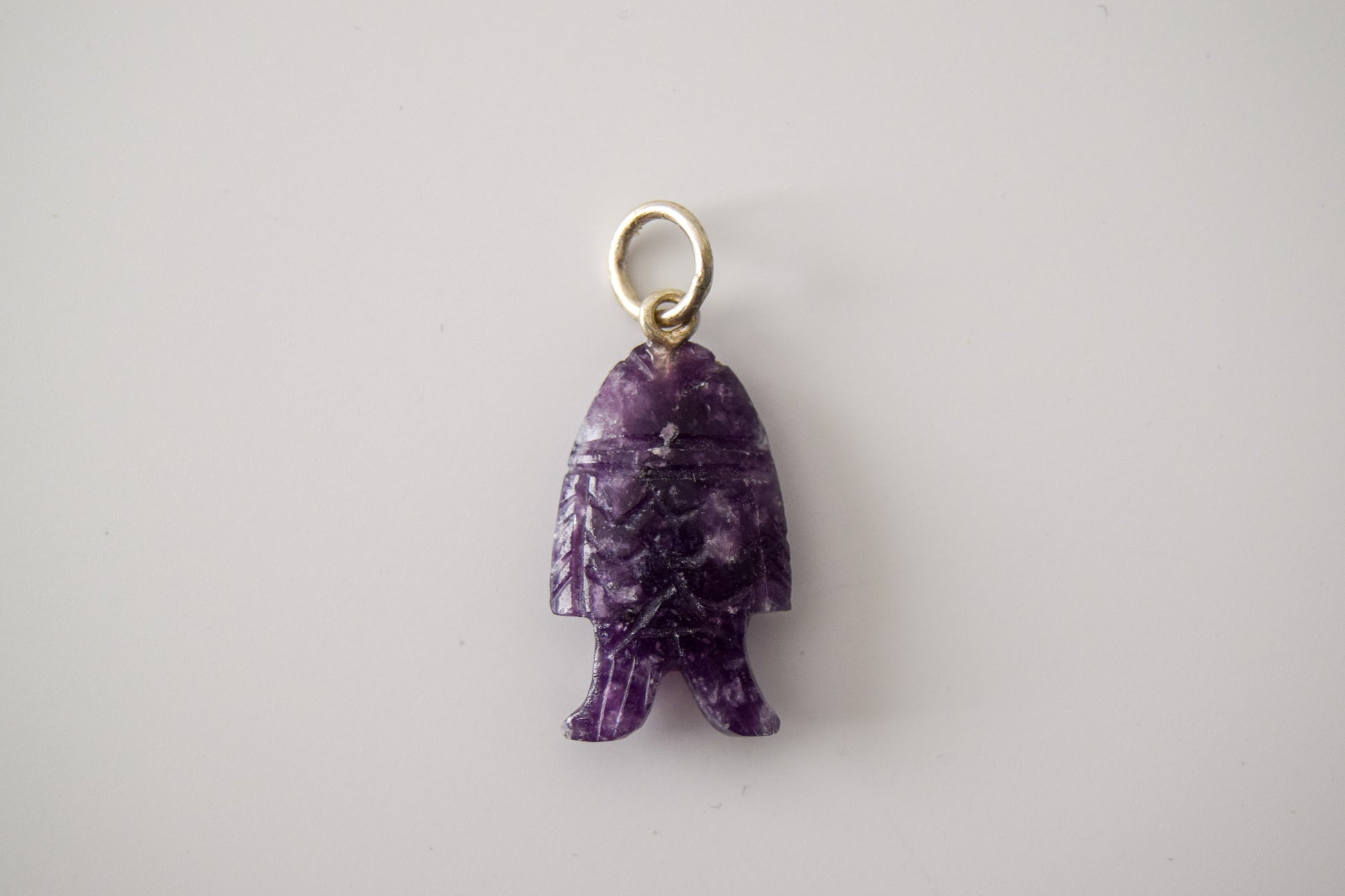 Intricately detailed, this versatile lepidolite fish charm features a delicate fish design carved from lepidolite gemstone, with the pendant ring made of silver plated material, it is perfect for various jewelry creations like a necklace or earrings, displayed on a neutral background