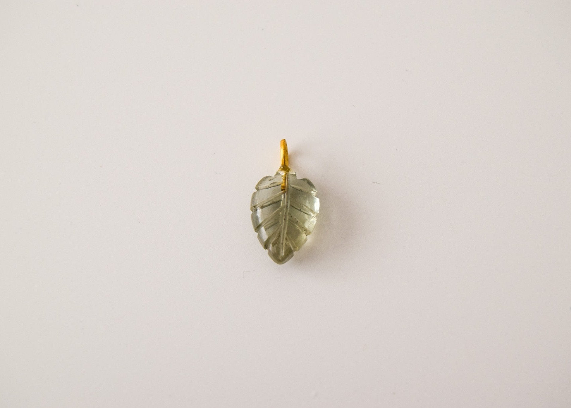 Intricately detailed, this versatile rutilated quartz leaf features a delicate leaf design carved from rose quartz gemstone, it is perfect for various jewelry creations like a necklace or earrings.