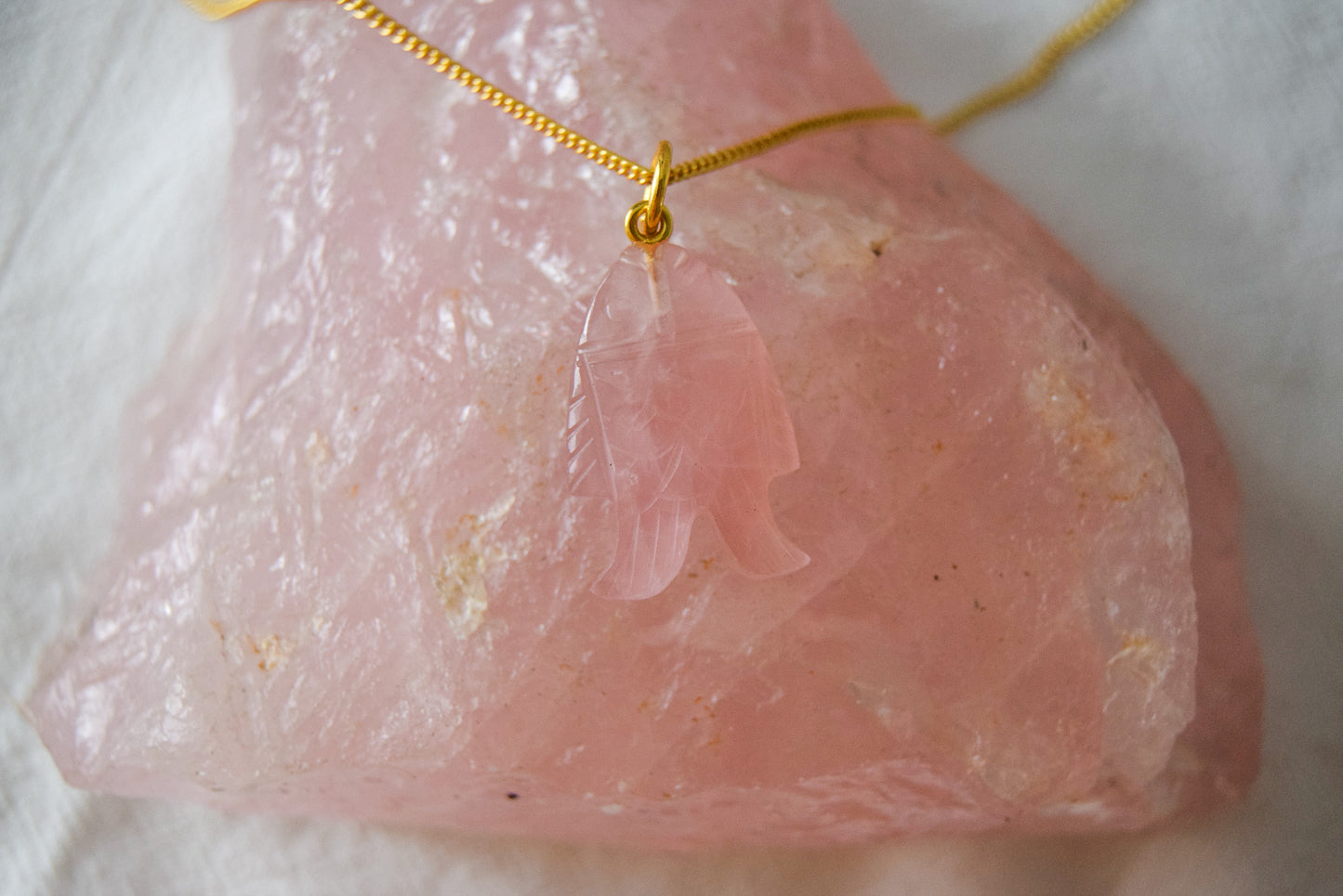 Versatile rose quartz fish trinket with intricate detailing, presenting a delicate fish design carved from rose quartz gemstone, ideal for enhancing various jewelry pieces