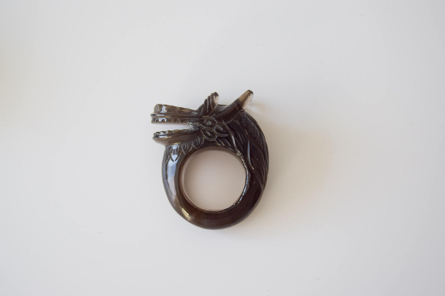 Smokey Quartz stone ring with carved and engraved dragon on a neutral background